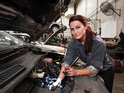 female holding tool fixing car engine